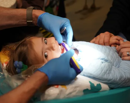 Girl getting teeth brushed