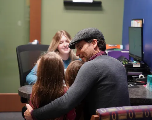Girl and dad talking with dental professional